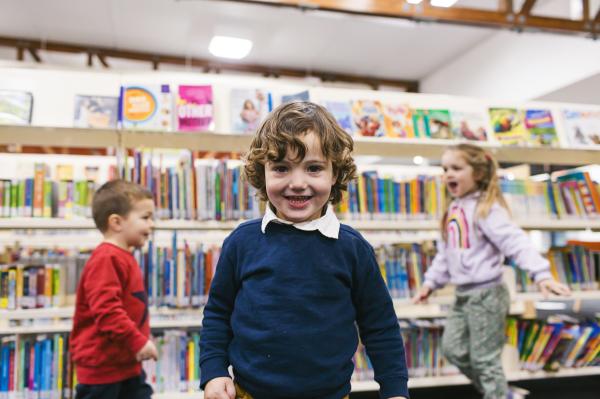 Toddlers enjoying a play session among bookshelves in a library.